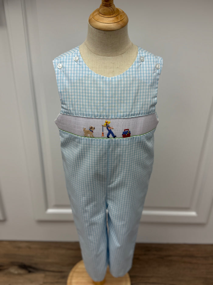 This Boys Gone Fishing Longall showcases a charming blue and white gingham pattern, highlighted by a detailed smocked fisherman &amp; his best friend embroidery on the front. Designed for comfort and style, it pairs perfectly with a classic Peter Pan collar shirt, creating an adorable and polished outfit ideal for playful days and special occasions.