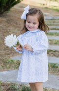 The Blue Blossom Billie Bishop Dress by Zuccini Kids delights with its charming blue floral print, timeless smocked neckline, and crisp white Peter Pan collar—crafted to make every moment picture-perfect for your little one. An exquisite choice for portraits and special occasions alike!