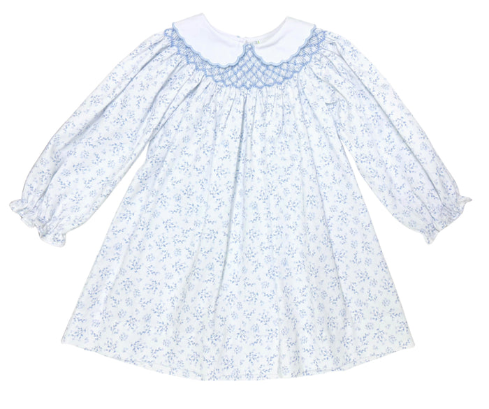 The Blue Blossom Billie Bishop Dress by Zuccini Kids delights with its charming blue floral print, timeless smocked neckline, and crisp white Peter Pan collar—crafted to make every moment picture-perfect for your little one. An exquisite choice for portraits and special occasions alike!