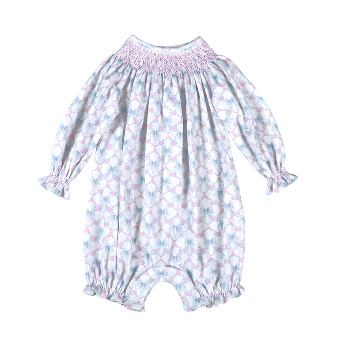 Delicate smocking adorns the neckline of this charming bubble, finished with a sweet bow detail. Soft floral print in calming blue tones creates an heirloom-quality piece perfect for special occasions or everyday elegance. The bishop bubble silhouette offers comfortable, timeless style for little ones.