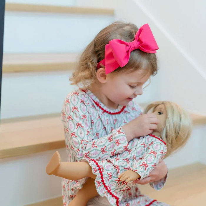 Dress your little one in enchanting elegance with the Carlin Girls' Dress featuring a charming Nutcracker Ballet print from Lila &amp; Hayes. Made from soft, breathable long-sleeve pima cotton, it ensures comfort all day. The flutter ruffle hem and delicate pom pom trim add playful details, while the button closure at the back makes dressing effortless. Perfectly pairs with the matching Doll Dress for an adorable coordinated look that captures the magic of the season.