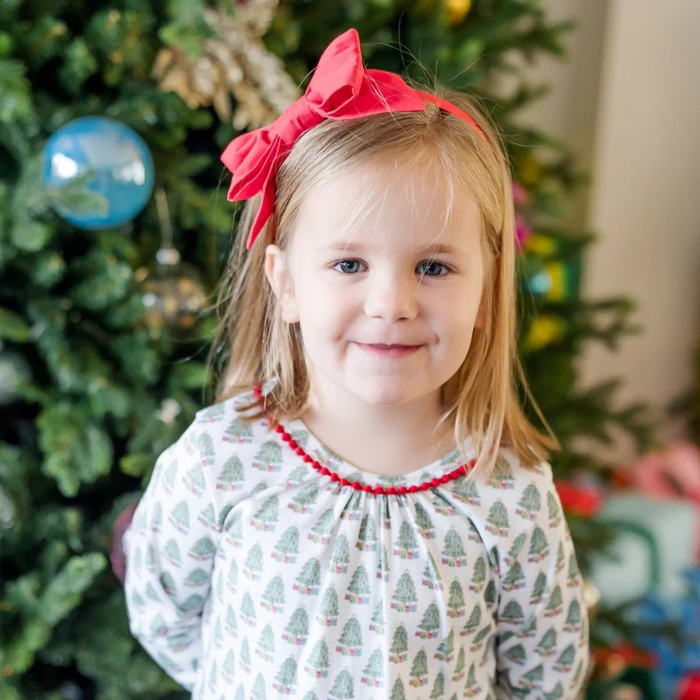 Dress your little one in cozy holiday charm with the Carlin Girls' Lounge Dress from Lila &amp; Hayes. Crafted from soft pima cotton, this long-sleeve dress features a delicate flutter ruffle hem and playful pom pom trim that add festive flair. The whimsical Christmas tree print captures the magic of the season, while the button closure at the back ensures easy dressing. Perfect for lounging or holiday gatherings, this dress combines comfort with joyful style for memorable celebrations.
