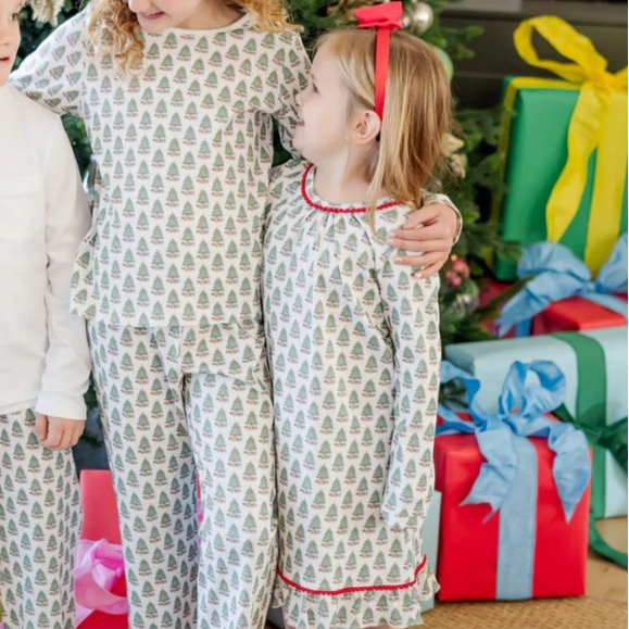 Dress your little one in cozy holiday charm with the Carlin Girls' Lounge Dress from Lila &amp; Hayes. Crafted from soft pima cotton, this long-sleeve dress features a delicate flutter ruffle hem and playful pom pom trim that add festive flair. The whimsical Christmas tree print captures the magic of the season, while the button closure at the back ensures easy dressing. Perfect for lounging or holiday gatherings, this dress combines comfort with joyful style for memorable celebrations.