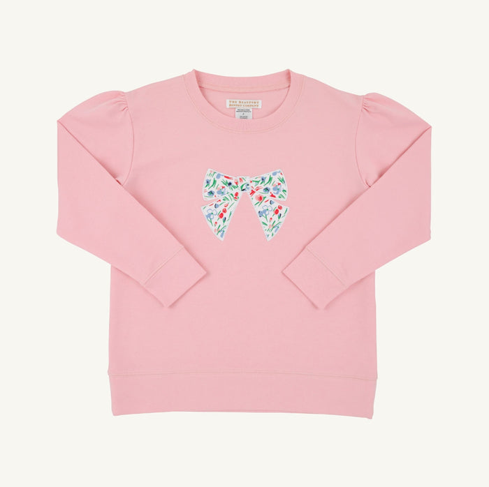 The Fair St Floral Bow Cassidy Comfy Crewneck by The Beaufort Bonnet Company combines cozy warmth with charming style. Its soft pink fabric, puff sleeves, and delicate floral bow create a timeless look perfect for tween girls’ school days and casual outings in cooler weather.