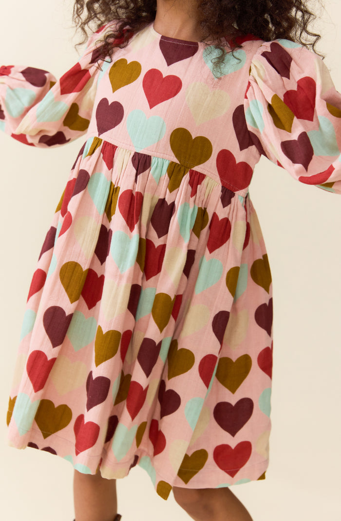 Pink Chicken’s Girls Bea Dress in Multi Harvest Hearts bursts with joyful colors that celebrate every moment. This vibrant dress brings playful charm and comfort to your tween’s wardrobe, making every day feel special and full of heart!