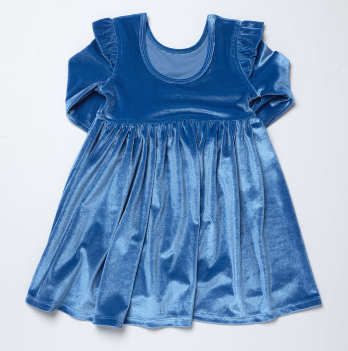 Pink Chicken’s Girls Natalie Dress in bright blue velour brings warmth and vibrant color to every fall day. Its soft, luxurious fabric and playful drop hem create effortless movement, making it an irresistible choice for girls who love comfort and style from toddler to tween.