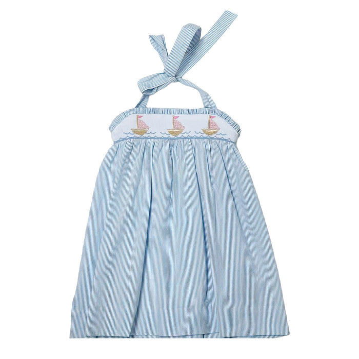 This enchanting Girl's Rachel Sailboat Stripe Dress captures summer's essence with classic blue and white seersucker stripes. The beautifully smocked bodice showcases charming embroidered sailboats, while the halter tie design ensures a perfect fit. An irresistible choice for warm-weather adventures, this quintessential summer dress is available for both toddlers and girls. Complete the look with the matching little sister short set for adorable coordinated outfits!