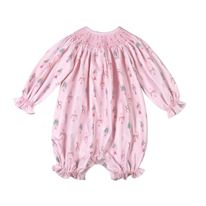 Baby Loren’s Pink Nutcracker Hand Smocked Pima Bishop Bubble wraps your little one in the softest Pima cotton, accented with delicate pink smocking and a charming nutcracker print. This exquisite bubble dress blends comfort and timeless holiday magic perfectly!