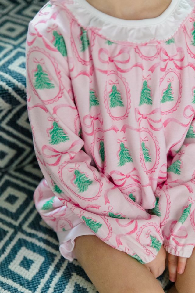 The Pink Tannenbaum Bubble by The Proper Peony delights with its soft pink Christmas pine print and crisp white ruffled collar, dressing your little girl in festive charm and timeless sweetness this holiday season.