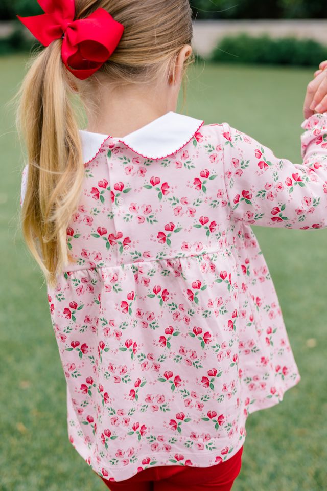 The Proper Peony’s Zinnia Blooms Tunic Set brings radiant red zinnias to life on a soft, light pink knit tunic paired with vibrant red leggings. Designed for infant girls, this set blends comfort and festive charm, making winter holidays unforgettable and effortlessly joyful!